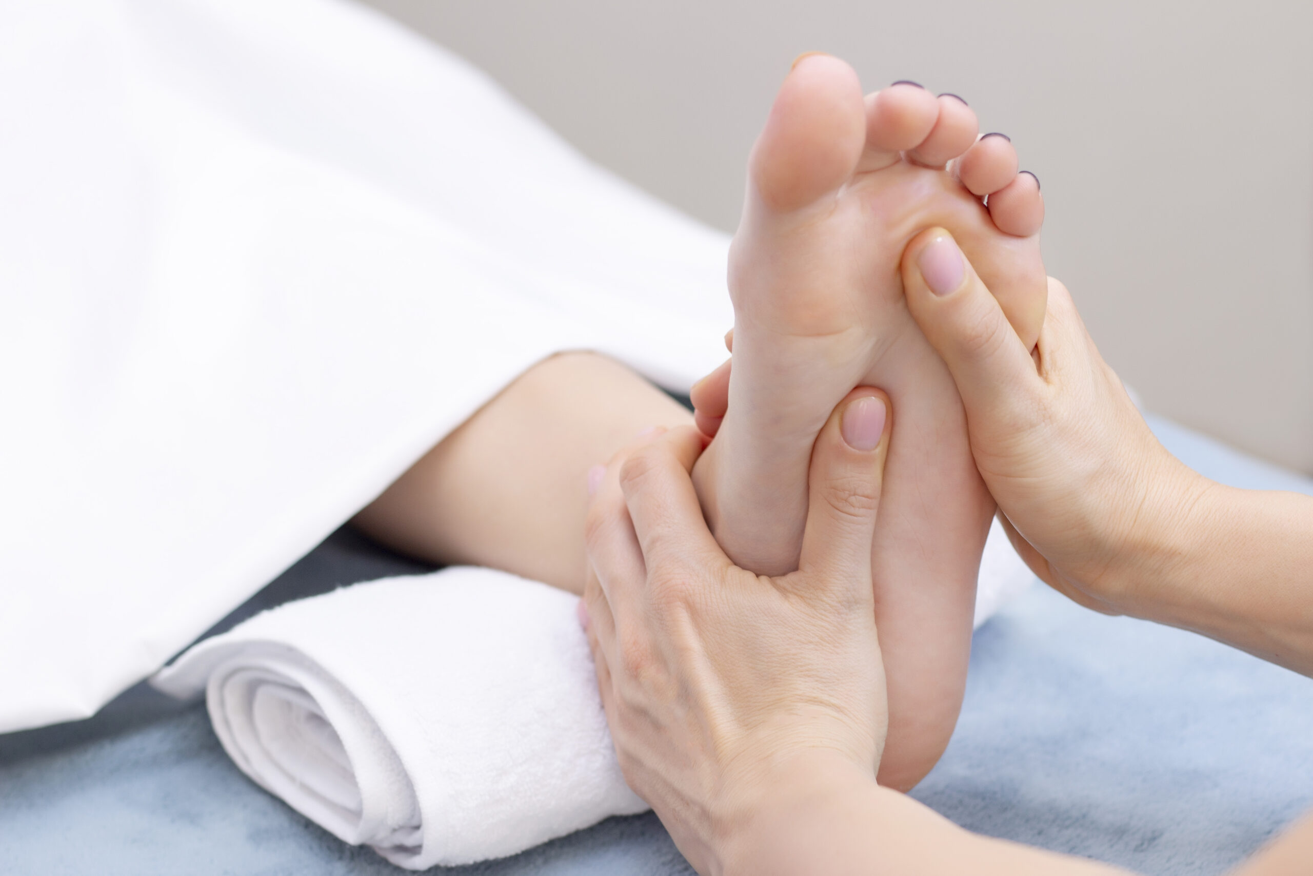 Young woman having feet massage in beauty salon, close up view